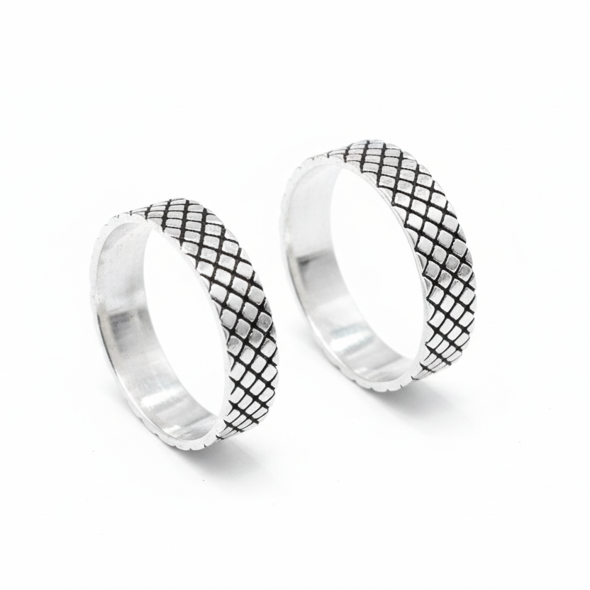 Pair of silver hoop earrings with black grid pattern on a white background