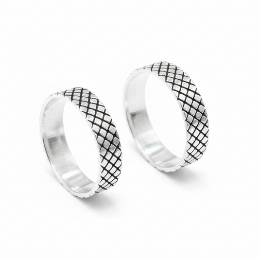 Pair of silver hoop earrings with black grid pattern on a white background