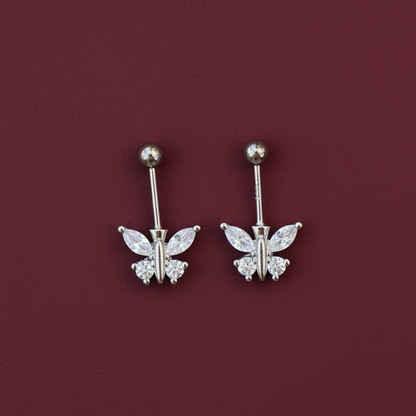 Pair of silver butterfly earrings on a burgundy background
