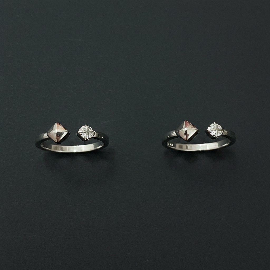 Silver jewelry with dangling charms on a pink textured fabric background