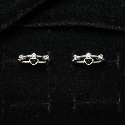 Silver key-shaped earrings on a pink fabric background