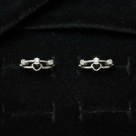 Silver key-shaped earrings on a pink fabric background