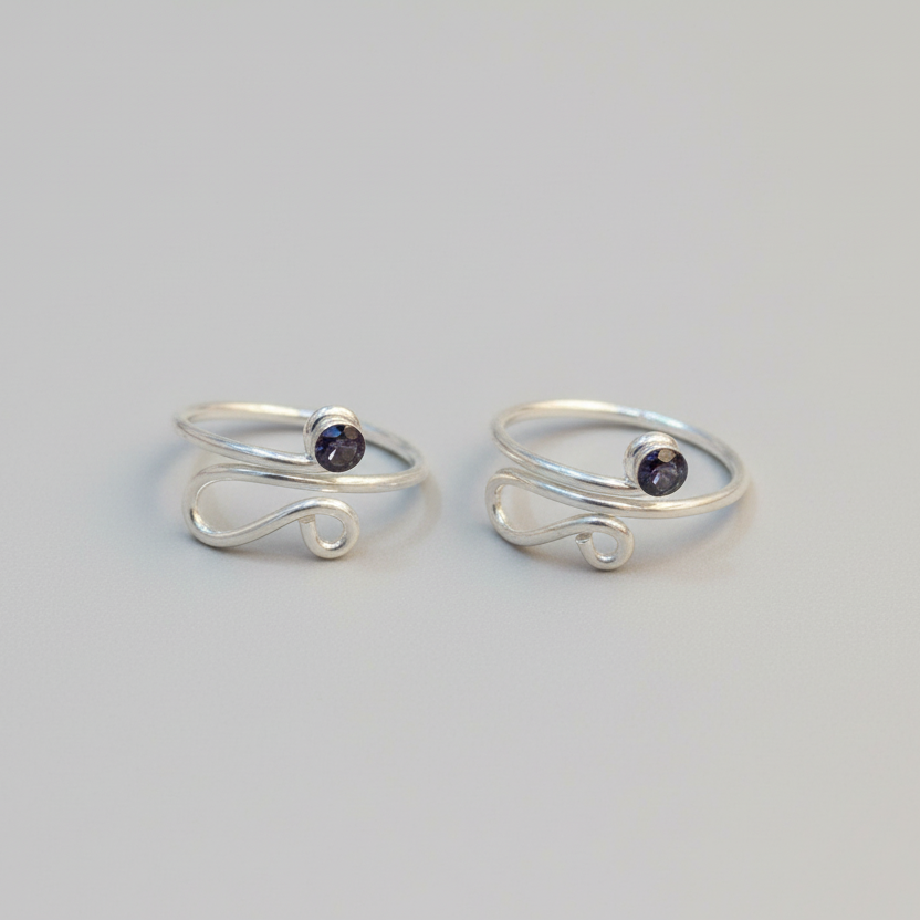 Two silver rings with small black stones on a light gray background