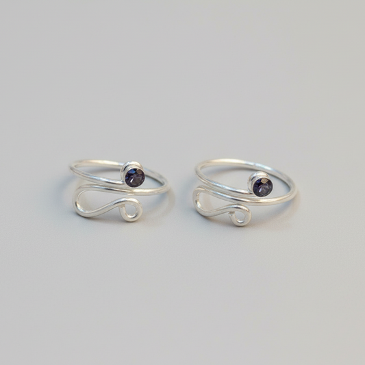 Two silver rings with small black stones on a light gray background