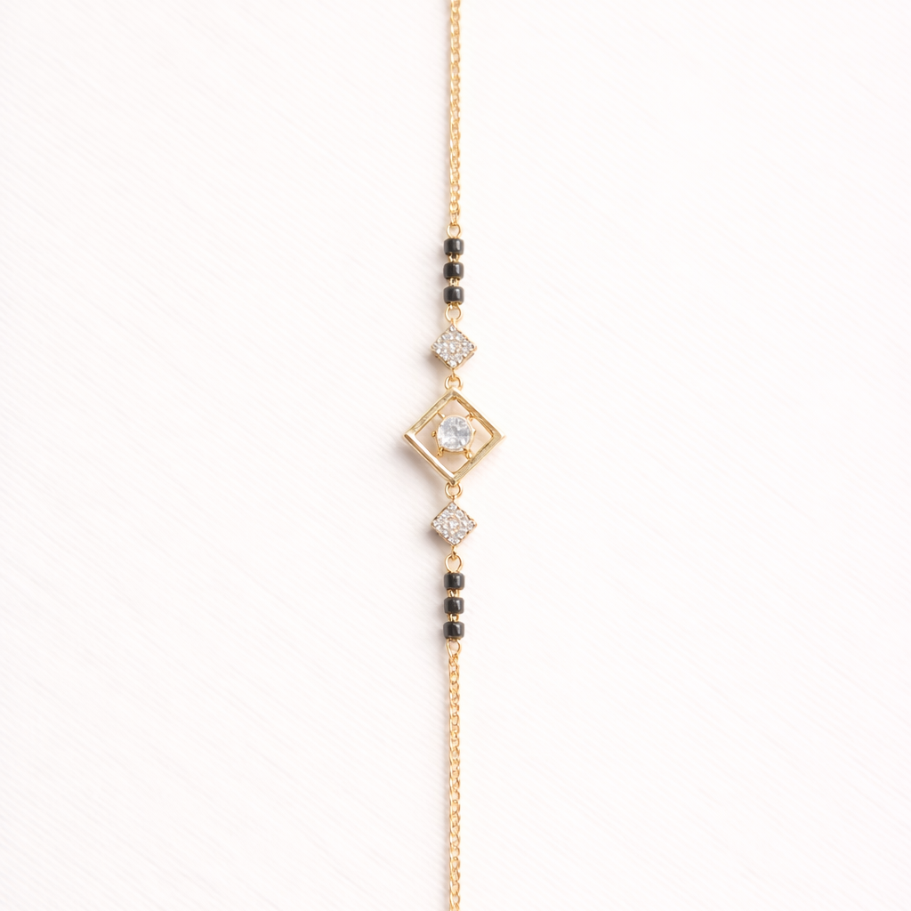 Gold bracelet with diamond-shaped clasp and beads on a white background