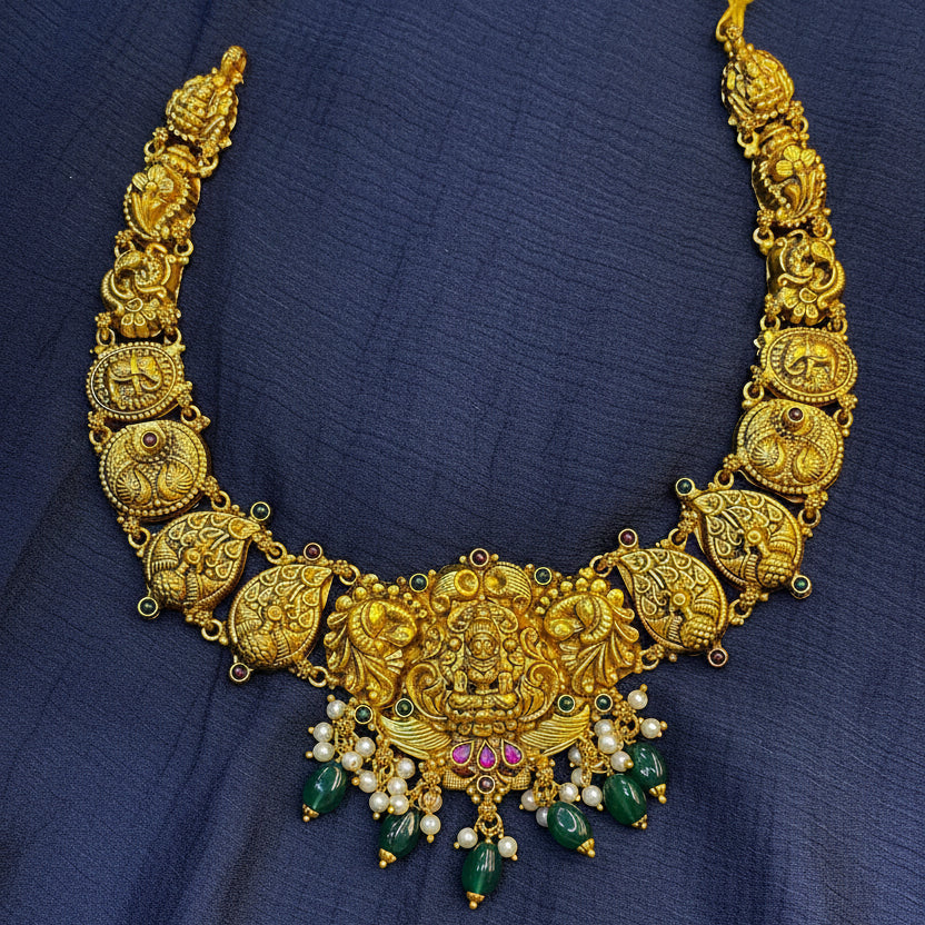 Gold necklace with decorative elements on a red fabric background
