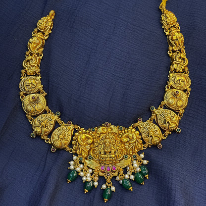 Gold necklace with decorative elements on a red fabric background