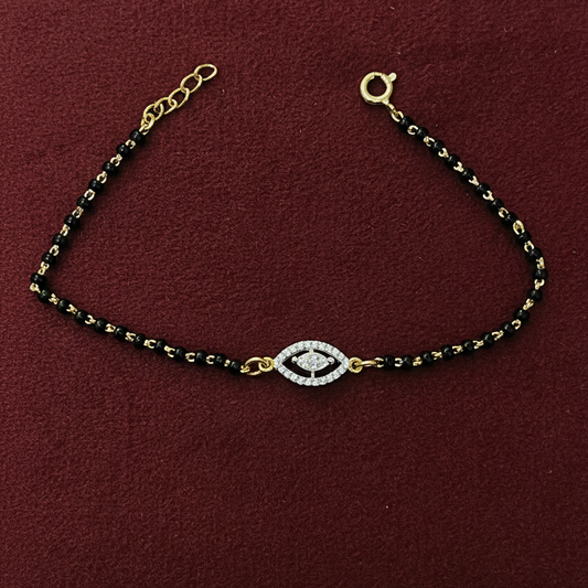 Black and gold beaded bracelet on a red fabric background