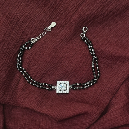 Bracelet with a square pendant on a red fabric background