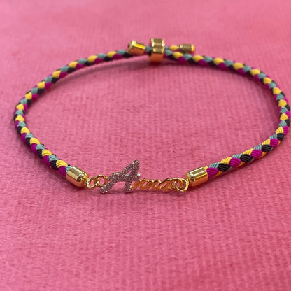 Gold-Plated Rakhi | CZ Name Script Charm on Multicolour Braided Silk Thread