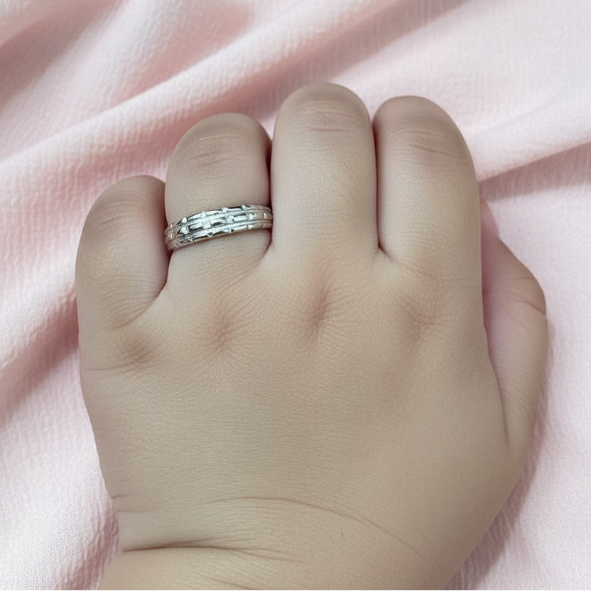 Silver ring on a finger with a pink fabric background