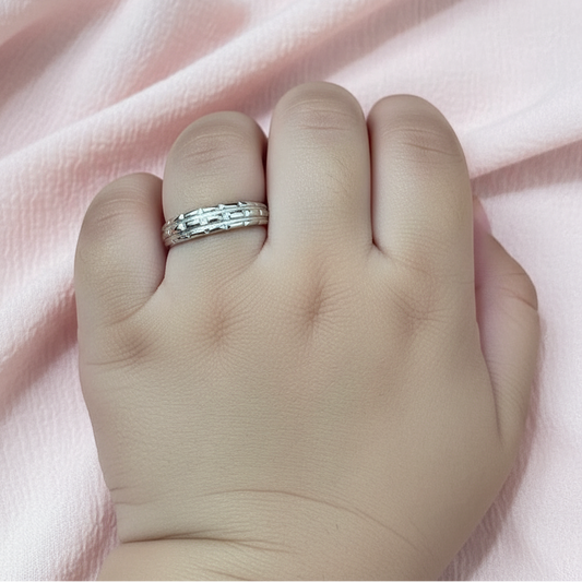 Silver ring on a finger with a pink fabric background