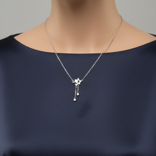 Silver necklace and earrings set in a gray box on a red fabric background