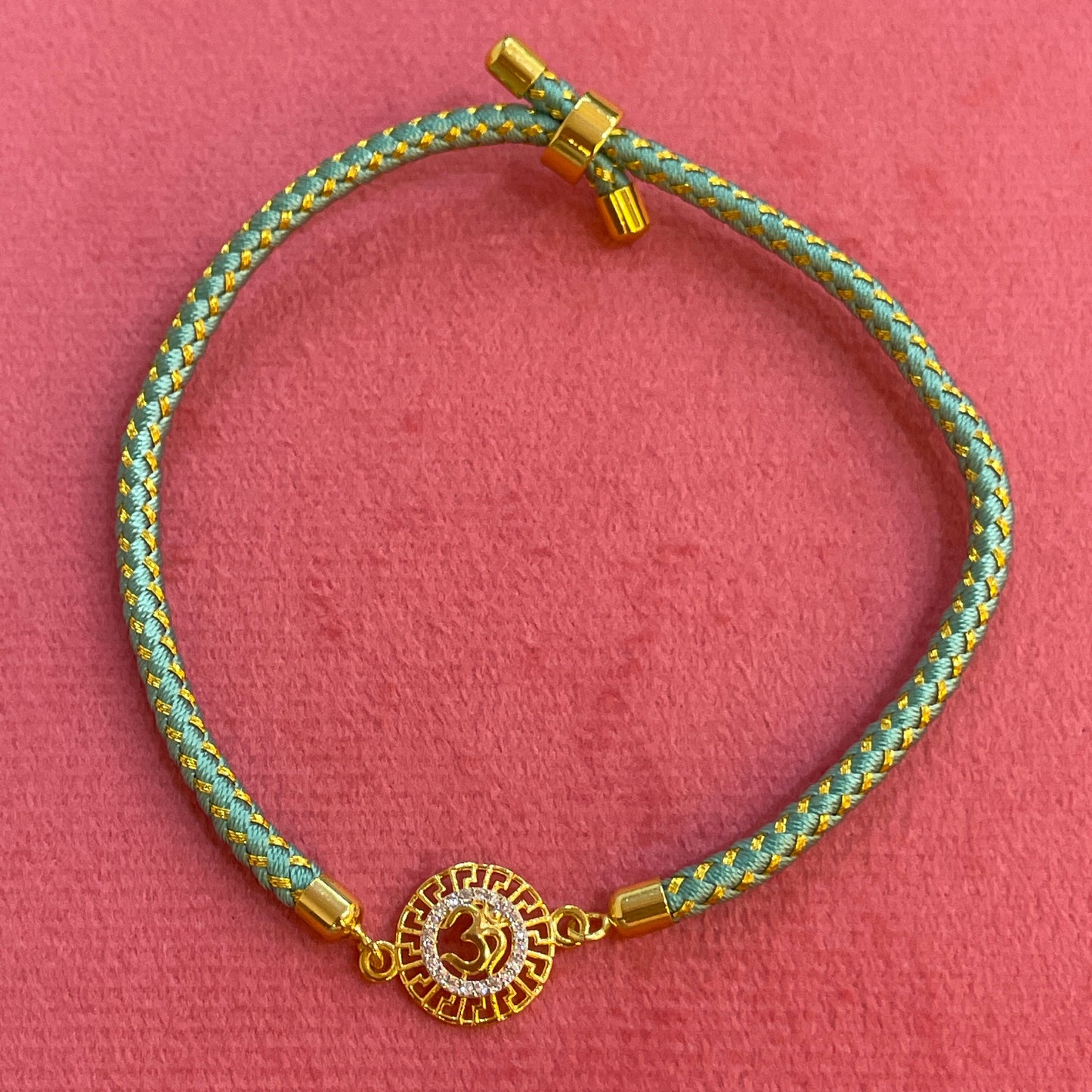 Silver Om Rakhi for Brother | Gold Plated CZ Charm with Teal Thread