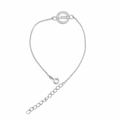 A delicate silver chain bracelet with a circular pavé-set logo charm and an adjustable extender chain, shown on a plain white background.