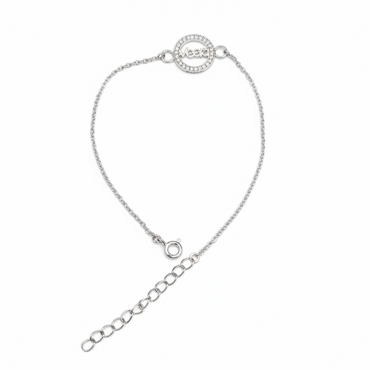 A delicate silver chain bracelet with a circular pavé-set logo charm and an adjustable extender chain, shown on a plain white background.