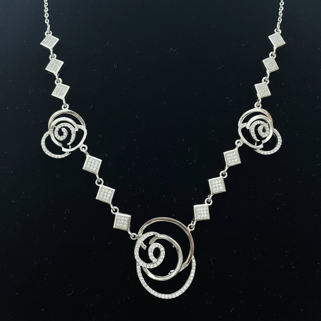 Silver necklace with floral designs on a red background