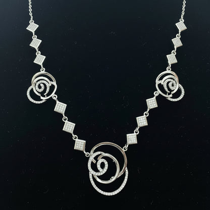 Silver necklace with floral designs on a red background