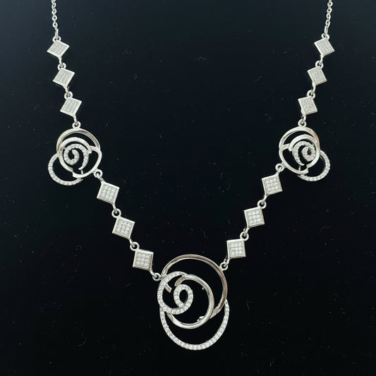 Silver necklace with floral designs on a red background