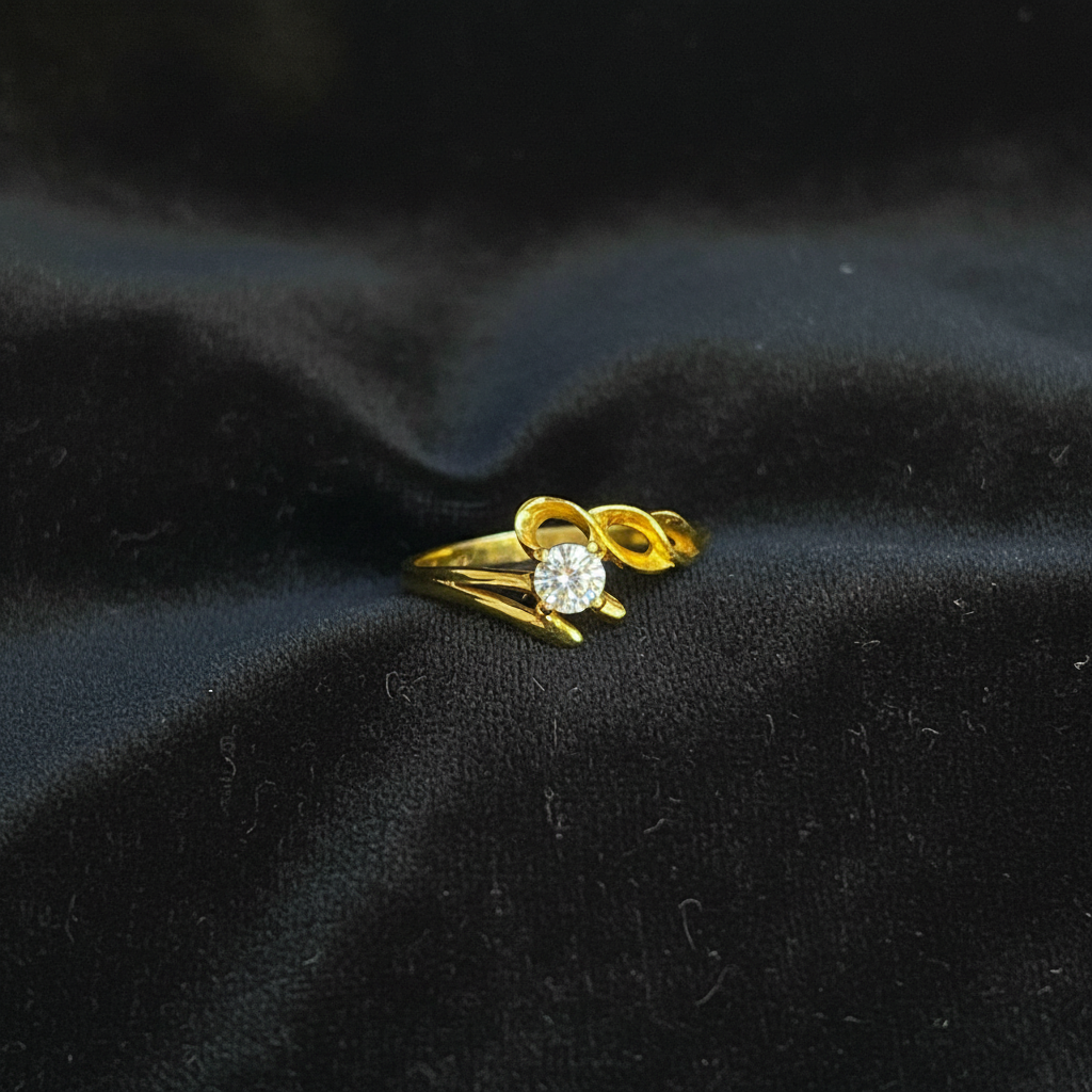 Gold ring with a diamond on red fabric