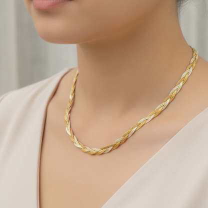 Gold necklace worn by a person against a neutral background