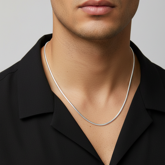 Man wearing a silver necklace against a neutral background