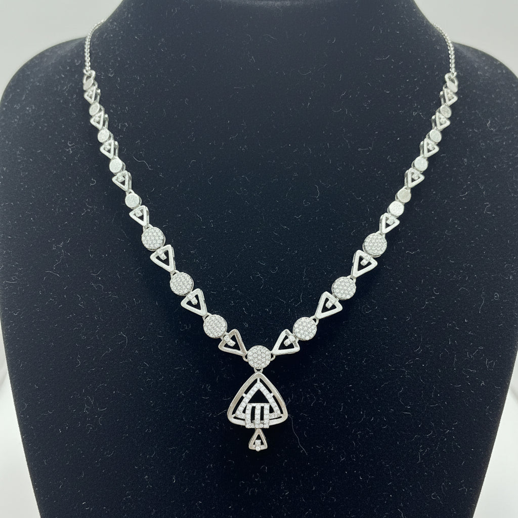Silver necklace with geometric design on a red cushion