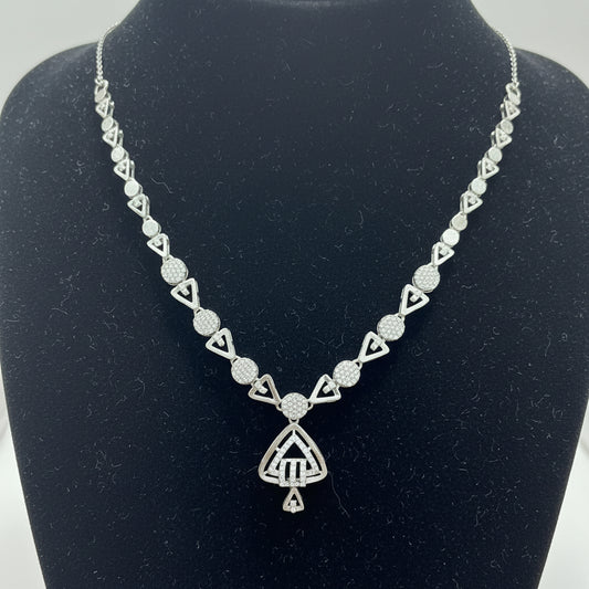 Silver necklace with geometric design on a red cushion