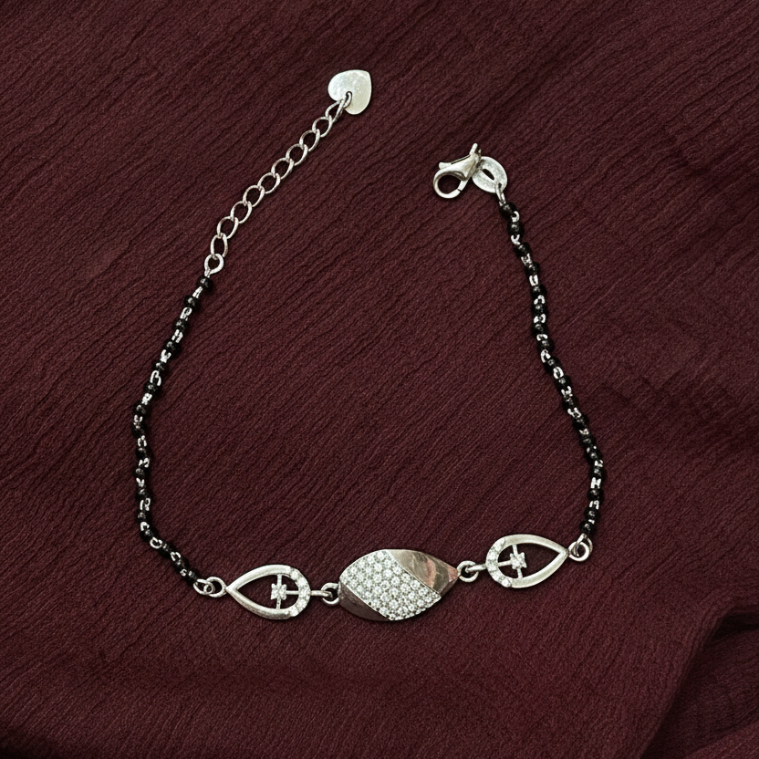 Silver bracelet with decorative elements on a red fabric background