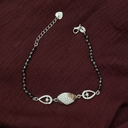 Silver bracelet with decorative elements on a red fabric background