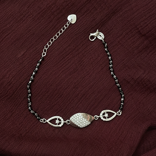 Silver bracelet with decorative elements on a red fabric background