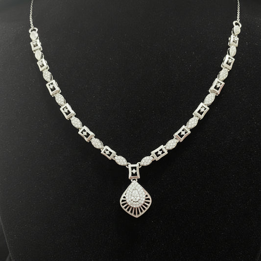 Silver necklace with a diamond pendant on a red velvet background