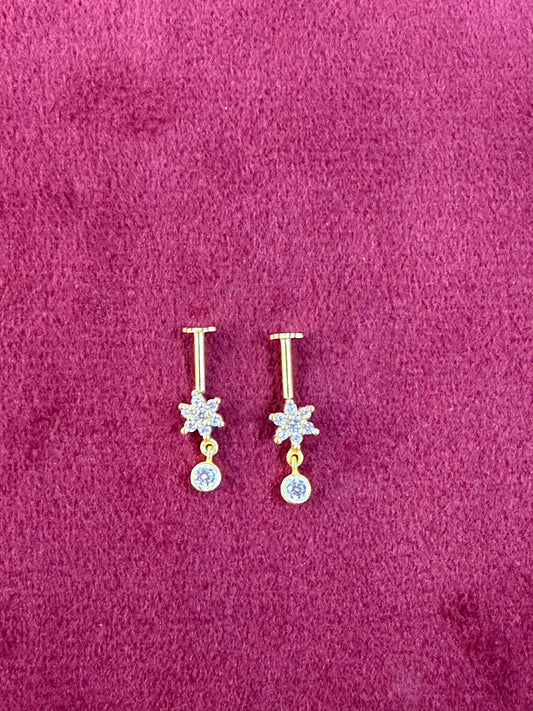 92.5 silver Pair of gold and silver floral earrings on a purple fabric background