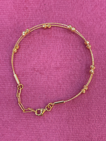 Gold bracelet on a purple textured background