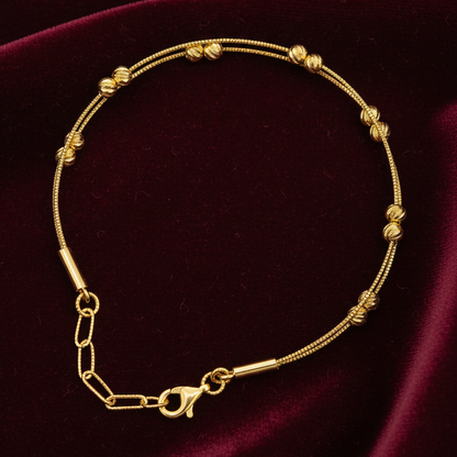 Gold bracelet on a dark purple fabric background
