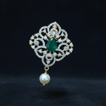 Decorative ring with emerald and pearl on a hand against a red background