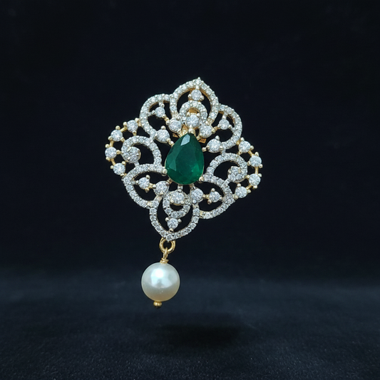 Decorative ring with emerald and pearl on a hand against a red background