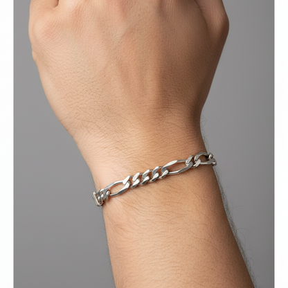 Silver chain bracelet on a wrist against a gray background