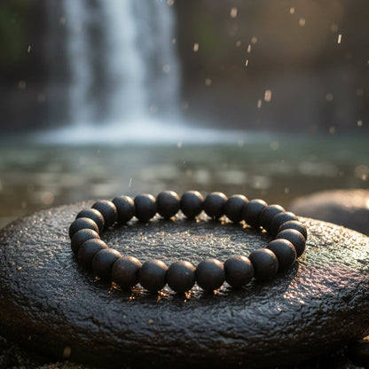 Black beaded bracelet on a red fabric background
