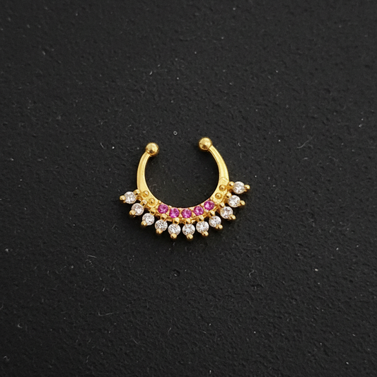 Gold nose ring with gemstones on a teal fabric background