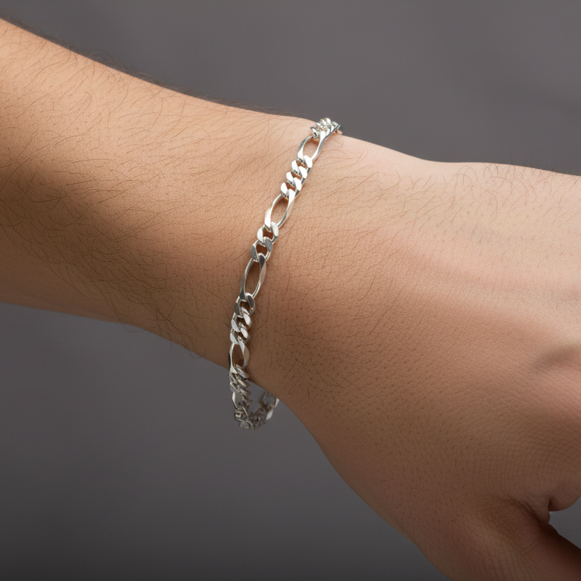 Silver chain bracelet on a wrist against a gray background