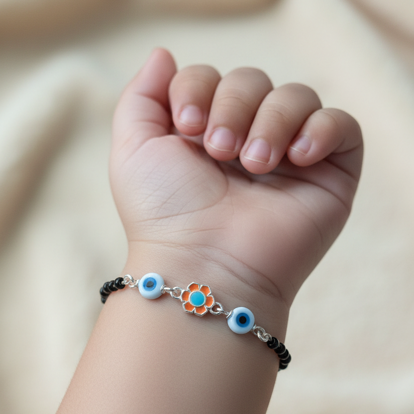 Child's wrist wearing a bracelet with eye-shaped charms on a neutral background