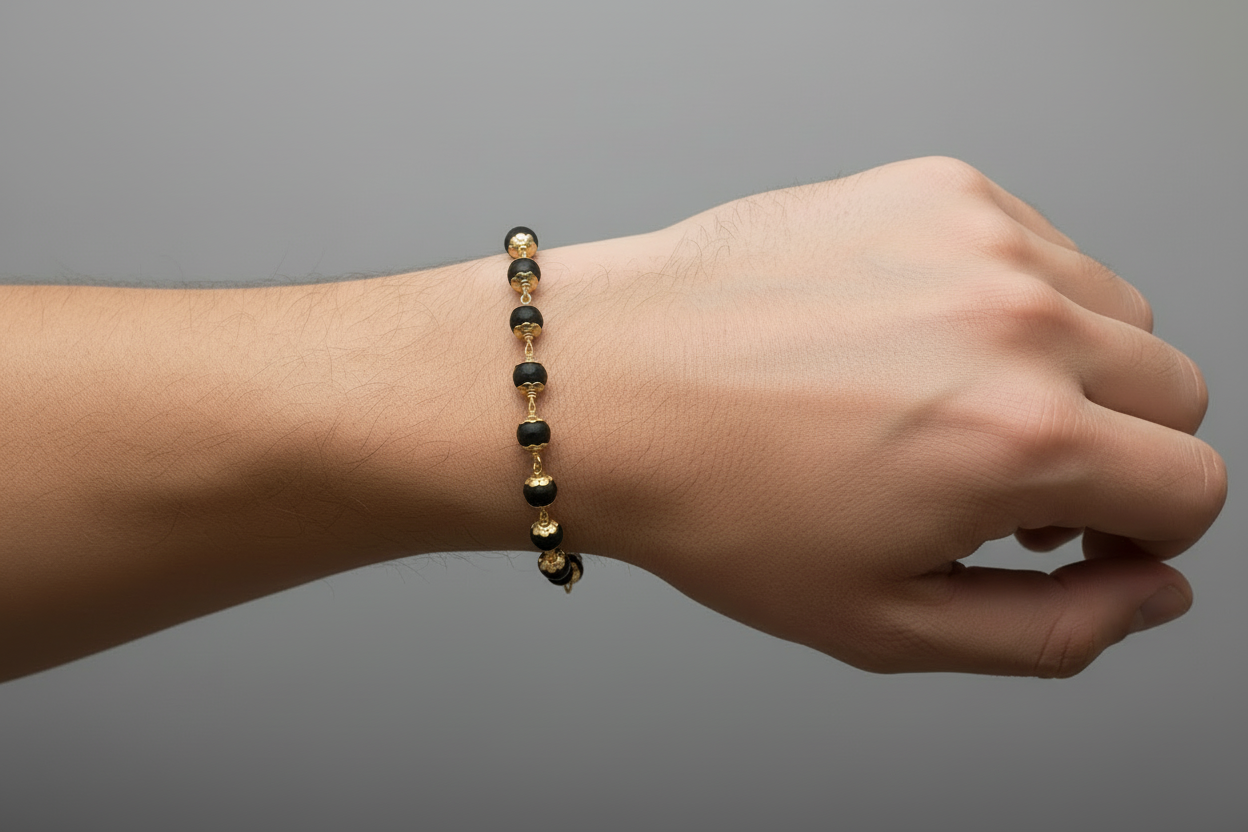 Bracelet with black beads and gold accents on a gray background