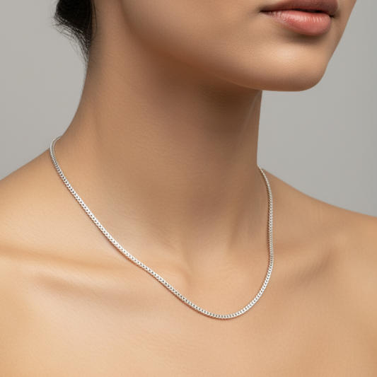 Silver necklace on a model against a neutral background