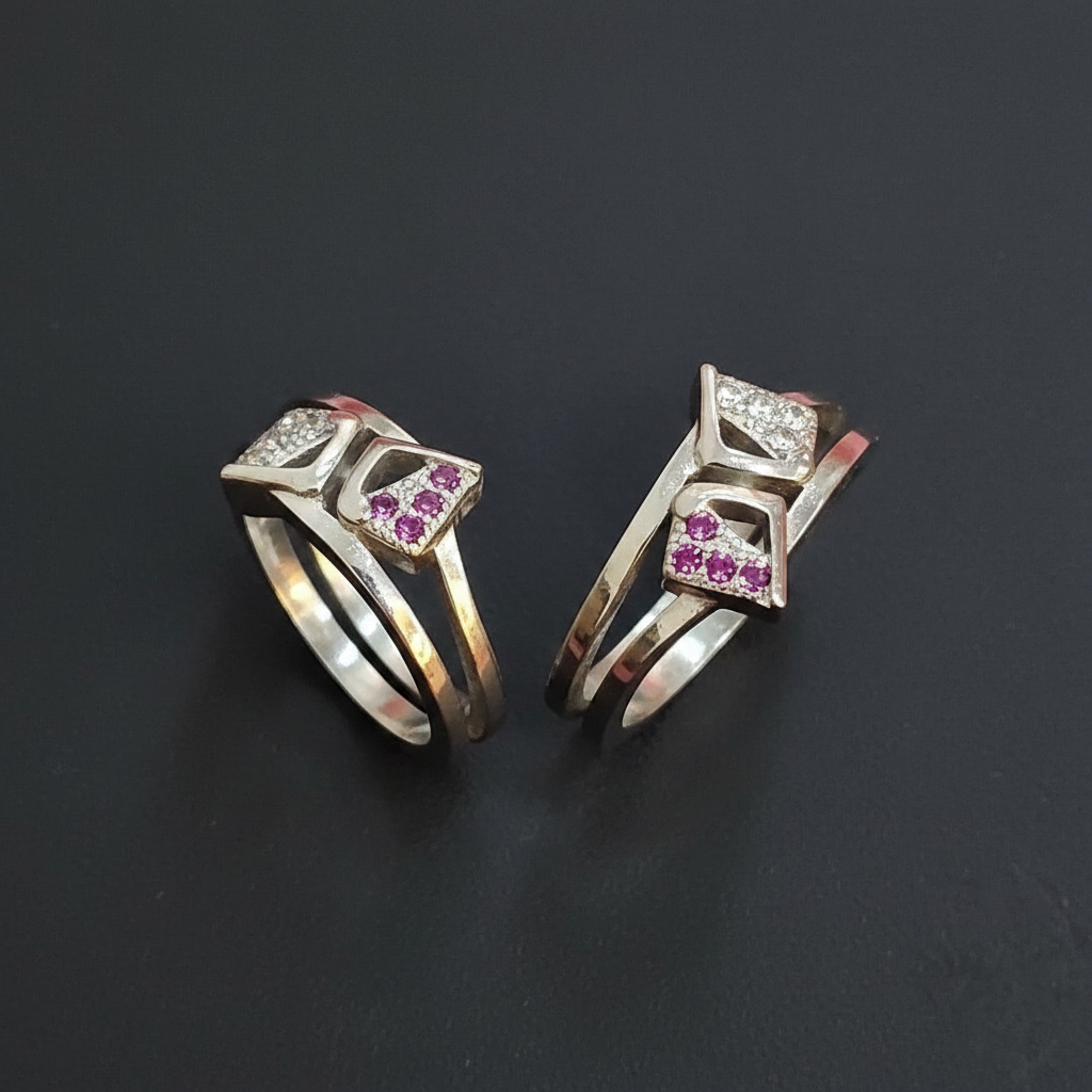 Two gold rings with gemstones on a finger against a pink background