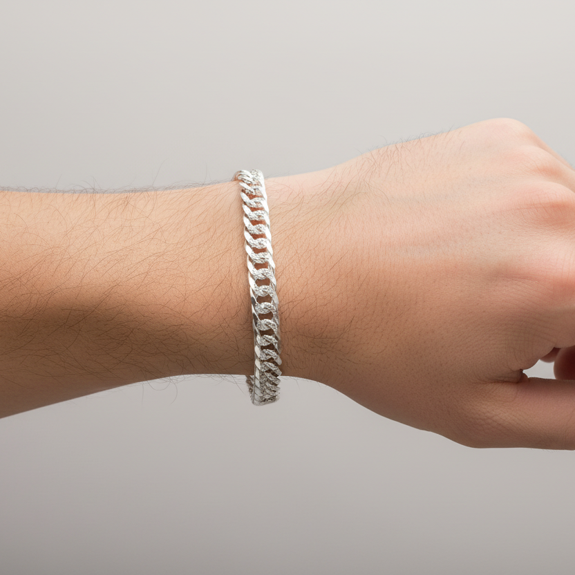 Hand wearing a silver bracelet on a plain background