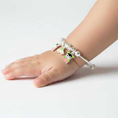 Child's foot wearing a anklet with small charms on a light background