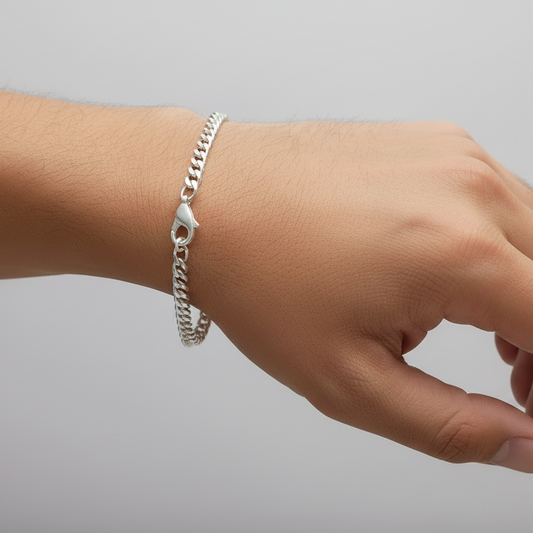 Silver bracelet on a person's wrist against a plain background