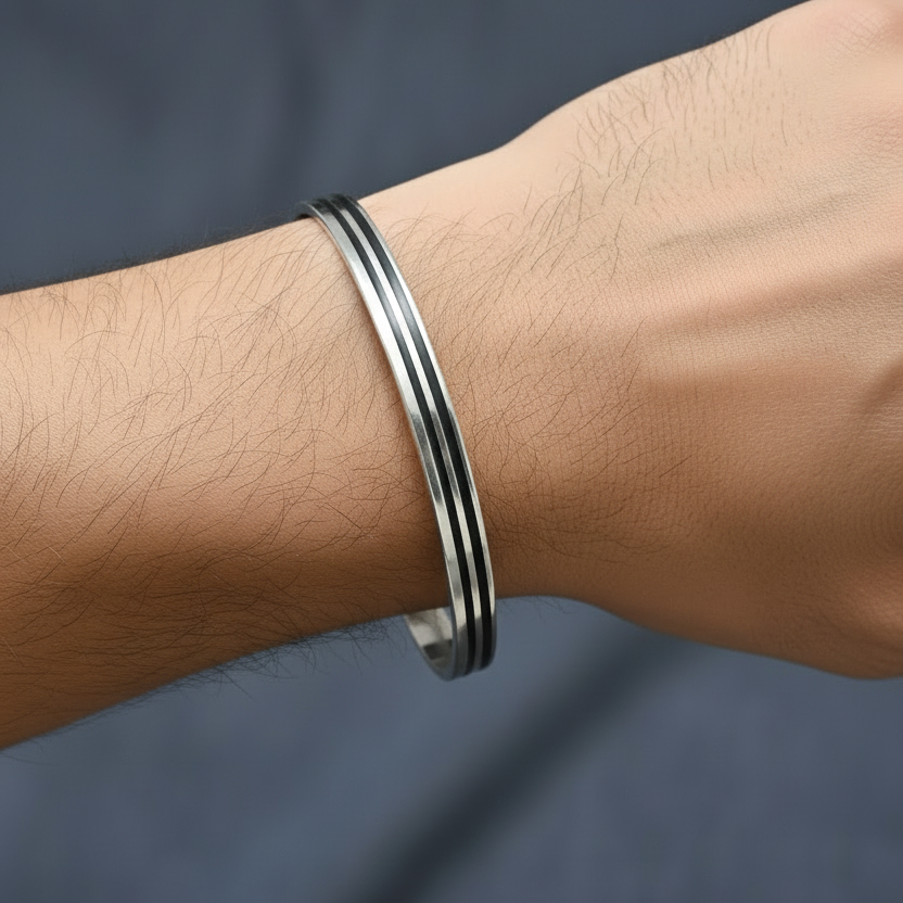 Silver bracelet on a wrist against a dark background