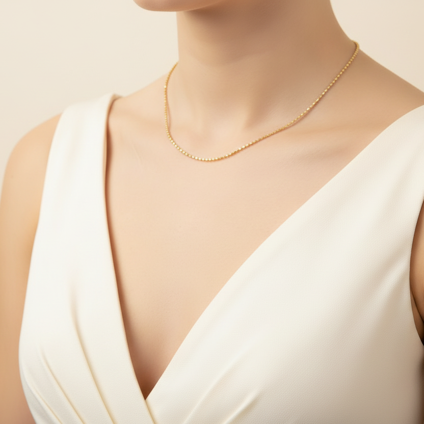 Gold necklace on a mannequin with a plain background